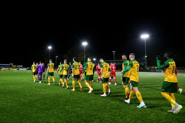Players of both teams walk out to the field of play prior to the Emirates FA Cup First Round Replay match between Horsham and Barnsley at The Camping World Community Stadium.