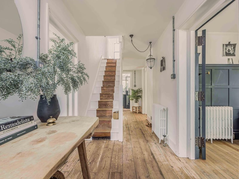 The bright, airy entrance hall features timber flooring