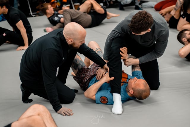 Head coach Jack Magee talks his students through a grappling position