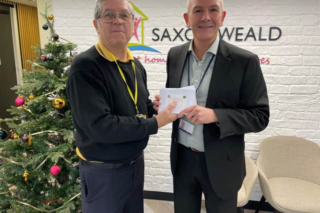 Food vouchers for families in need were handed over by Horsham Lions president Miles Loveday to Saxon Weald chief executive Steven Dennis
