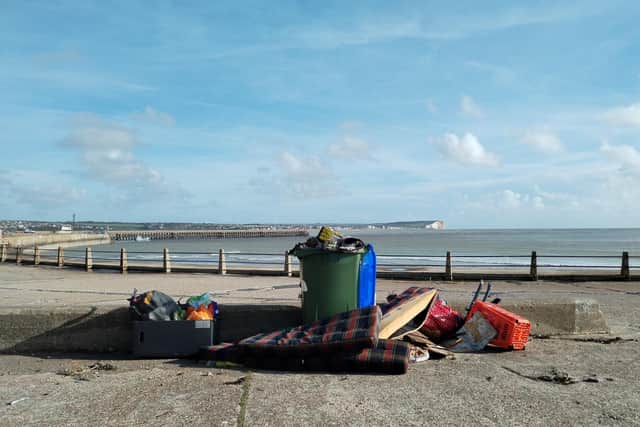 A pile of rubbish left on Newhaven seafront is being blown into the sea