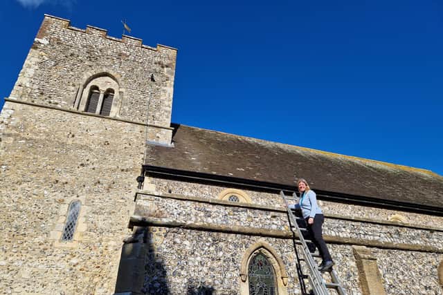 Vicar, the Rev Natalie Bawcutt, inspects the solar panels, which are invisible from the ground