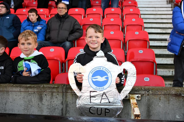 STOKE ON TRENT, ENGLAND - JANUARY 06: A fan of Brighton & Hove Albion fan holding a cut out of the FA Cup trophy during the Emirates FA Cup Third Round match between Stoke City and Brighton and Hove Albion at Bet365 Stadium on January 06, 2024 in Stoke on Trent, England. (Photo by Ben Roberts Photo/Getty Images)