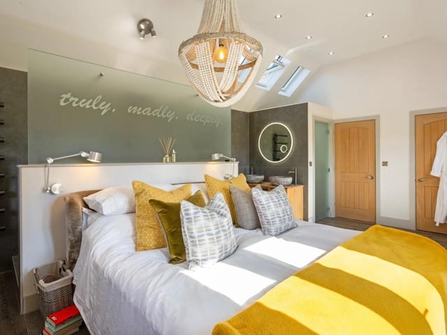The principal bedroom features a wall divide with a shower space