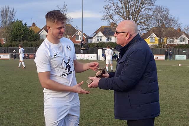 Max Thompson recently made his 100th appearance for Eastbourne United. Here, he is presented with a trophy by United legend Jim Bean, to commemorate the achievement | Picture supplied by EUFC