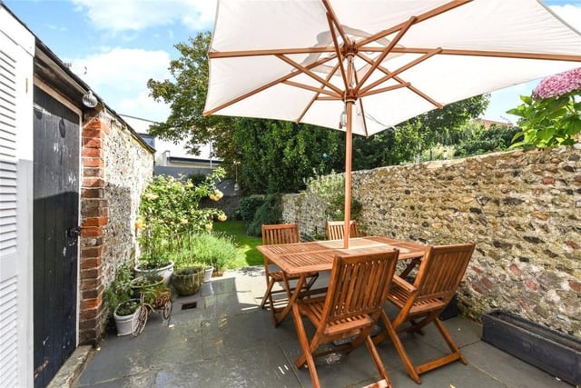 The rear garden is enclosed by a traditional flint wall and features a sun terrace.