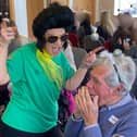 Juliette from Dementia Singing Experience dancing with attendee playing the harmonica