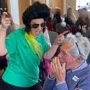Juliette from Dementia Singing Experience dancing with attendee playing the harmonica