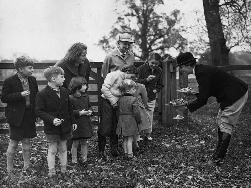 Young followers of the Crawley and Horsham Foxhounds being offered some cake by a member of the hunt on 6th November 1954/