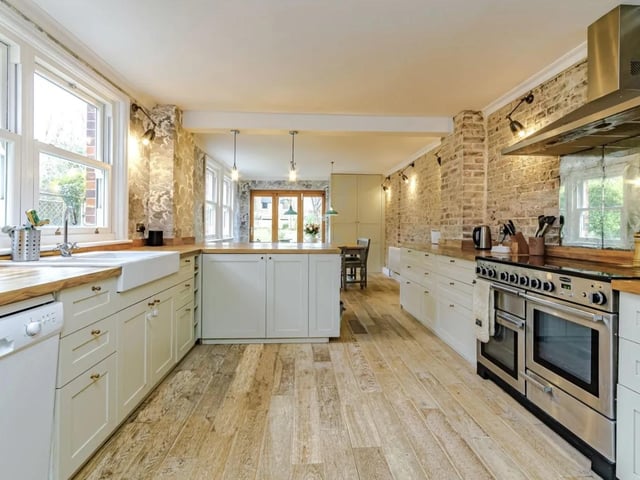 The spacious kitchen/dining room has an extensive range of base and tall units with oak work surfaces