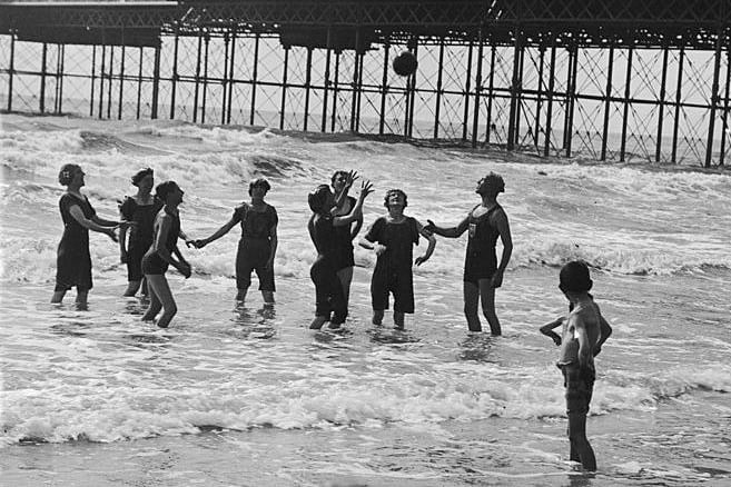 September 1919:  Bathers play ball on Brighton beach.