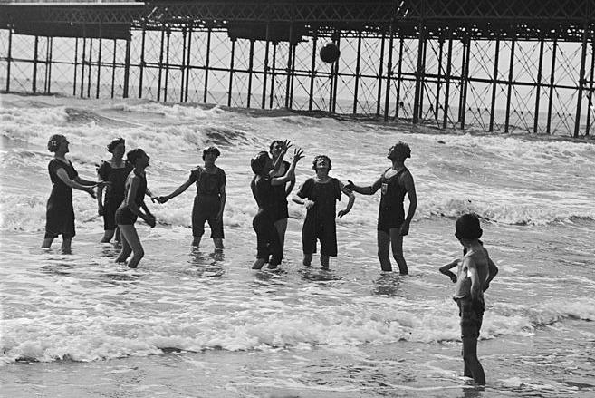 September 1919: Bathers play ball on Brighton beach.