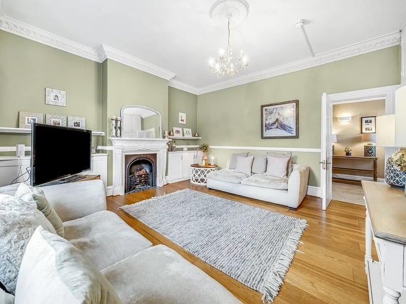A reception room at the front of the house has oak-wood flooring, a bay window, a feature fireplace and original coving