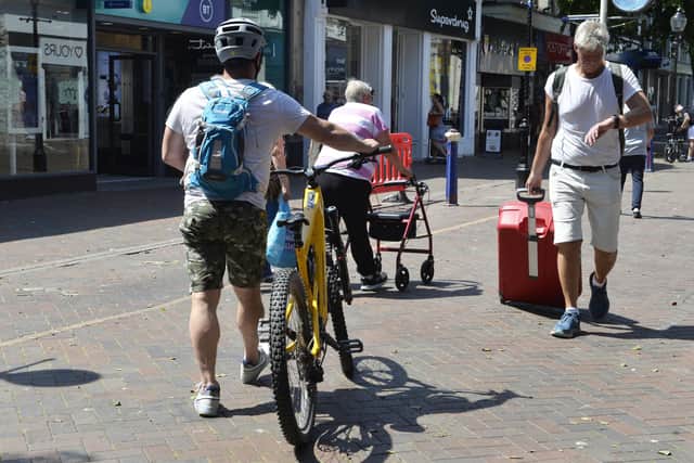 A cyclist walking in Terminus Road, Eastbourne in 2022. Photo: Jon Rigby