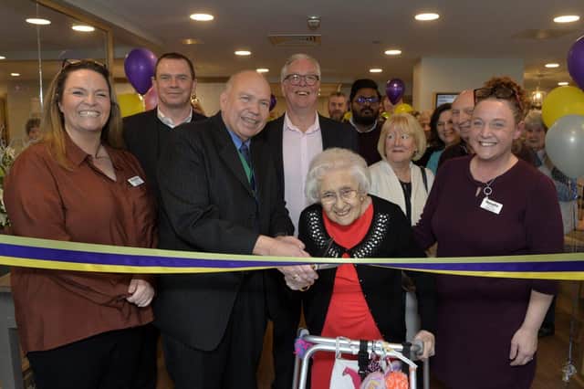 Ethel Thomas pictured centre and the Deputy Mayor (left centre) cutting the ribbon to open the home officially. 