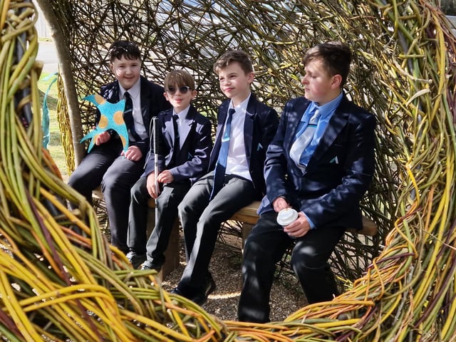 Students enjoying a chat inside the giant woven willow egg