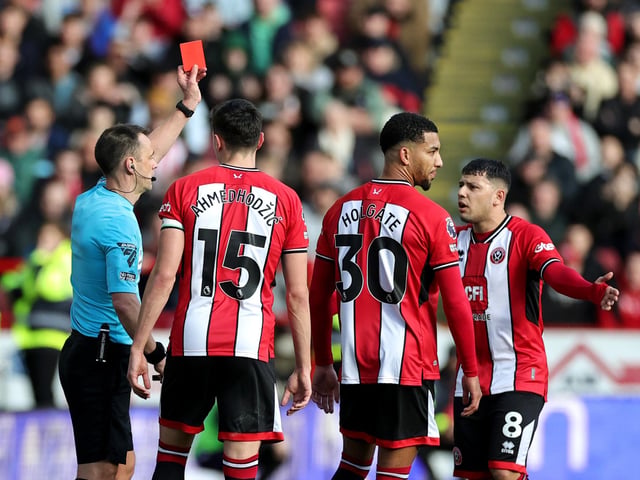 Referee Stuart Attwell shows a red card to Mason Holgate of Sheffield United after a VAR review during the Premier League match between Sheffield United and Brighton & Hove Albion at Bramall Lane on February 18, 2024 in Sheffield, England. (Photo by David Rogers/Getty Images)
