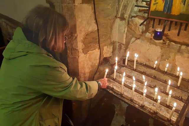Jean Barrs lights a candle in memory of Queen Elizabeth II at St John's Church