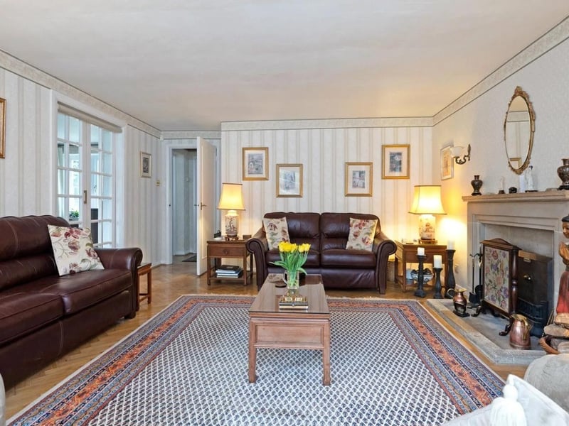 The formal drawing room has a large bay window and a fireplace