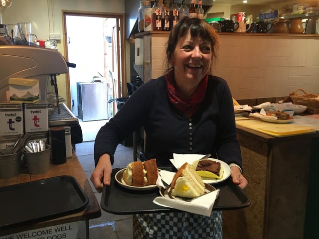 Mandy from Jungle Tea Rooms with large slices of cake on their way to the table during the Tasty Countryside Walk for St Barnabas House