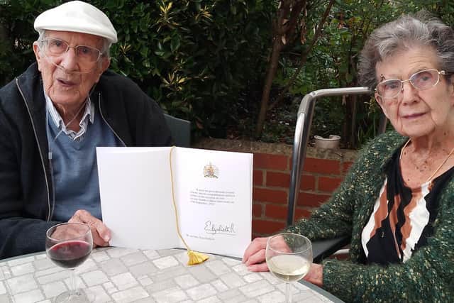 Eunice pictured with Peter on their 74th wedding anniversary last September, with a card from the Queen that arrived at their home in Findon on the day Queen Elizabeth died. Photo contributed