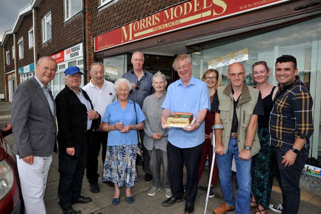 Brian Jackson holding a cake made by Claire Sherriff, daughter of Brenda Edkins, outside Morris Models in Lancing with the surprise gathering for his retirement. Picture: S Robards SR2208273