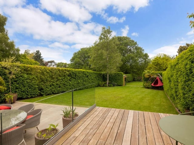 The garden is mostly laid to lawn and is enclosed by mature clipped hedges