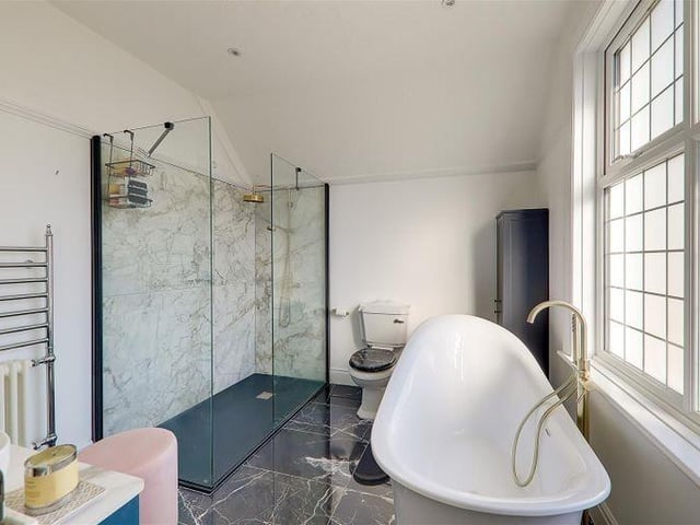 The en-suite bathroom on the first floor has a freestanding slipper-style bath