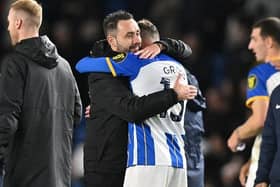 Brighton's Italian head coach Roberto De Zerbi (L) embraces Brighton's German midfielder Pascal Gross