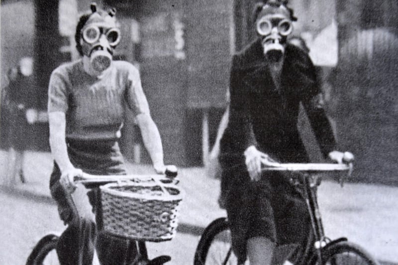 Women wearing gas masks while on a bike ride. (Copy photograph by Jon Rigby)