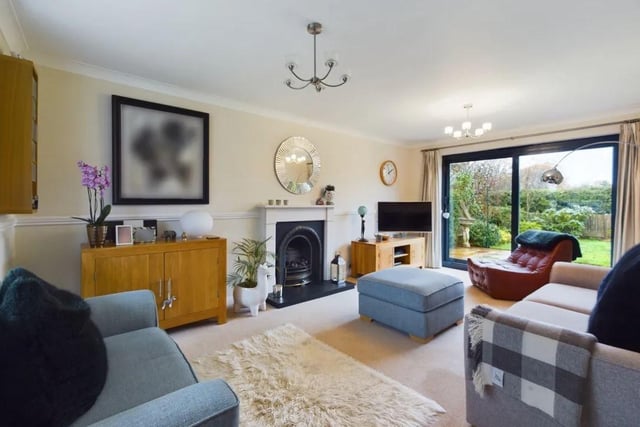 There is a large living room with a bay window and a stunning fireplace, with a living flame gas fire.