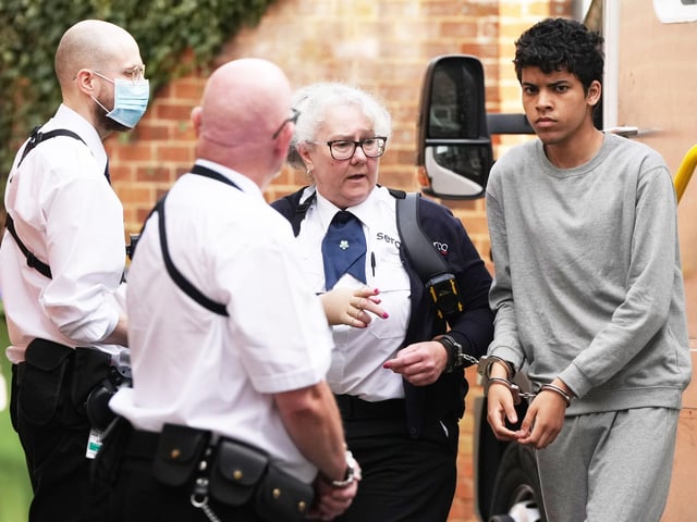 A Sussex teenager accused of murdering his father and attempting to kill a woman and a boy has been pictured arriving at court in handcuffs.