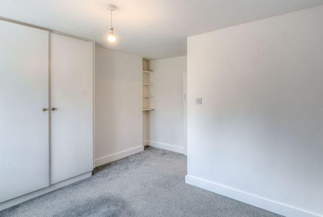 The master bedroom has a range of fitted cupboards and views of the front garden.
