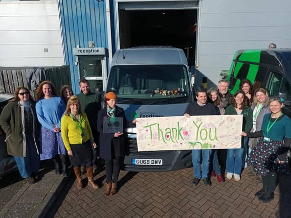 Foodbank team hold gratitude banner made by clients needing to use the foodbank outside the Brampton Road warehouse