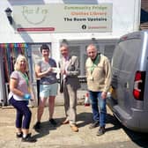 Hailsham mayor Cllr Paul Holbrook handing grant cheque to Pass It On founder Zoe Prior, pictured with project volunteers
