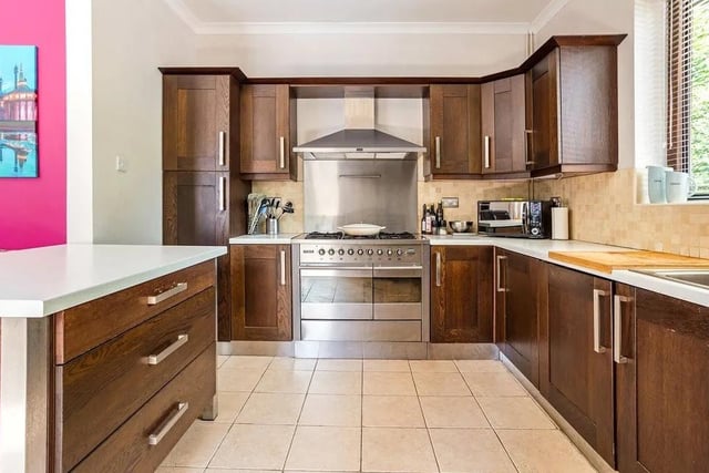 The kitchen has Shaker-style cabinets, house integrated appliances and a split stable door