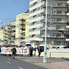 Protestors marching behind a 'We are all migrants' banner near Hove lawns on Saturday, October 17. Photo: Eddie Mitchell