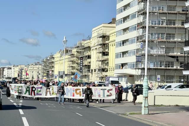 Protestors marching behind a 'We are all migrants' banner near Hove lawns on Saturday, October 17. Photo: Eddie Mitchell