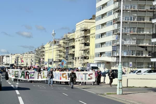 Protestors marching behind a 'We are all migrants' banner near Hove lawns on Saturday, October 17. Photo: Eddie Mitchell