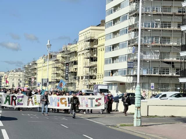 Protestors marching behind a 'We are all migrants' banner near Hove lawns on Saturday, October 17. Photo: Eddie Mitchell