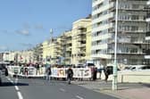 Protestors marching behind a 'We are all migrants' banner near Hove lawns on Saturday, October 17. Photo: Eddie Mitchell