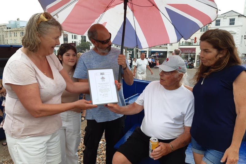 Rita Garner presents Norman Bashford with a certificate marking three generations of fishing in Worthing