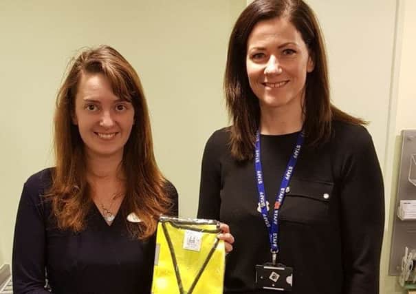 Tracy Parkinson and Krissy Morrison with one of the 250 donated high visibility vests