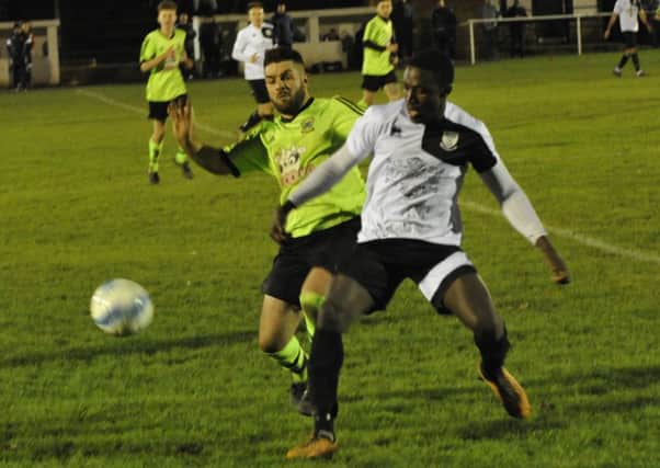 Bexhill United wide player Georges Gouet tries to hold off a Ringmer opponent. Pictures by Simon Newstead