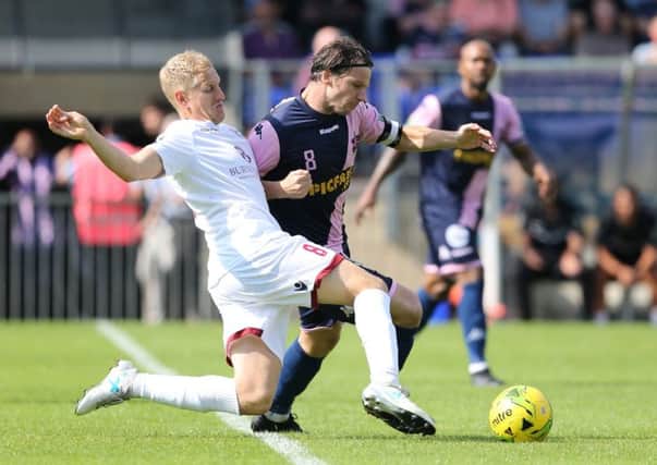 Simon Johnson effects a sliding tackle in an FA Cup tie against Dulwich Hamlet at the start of September. Picture courtesy Scott White