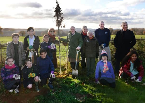 Lord Gardiner planting a tree with local schoolchildren to mark National Tree Week, during a visit to the South Downs National Park