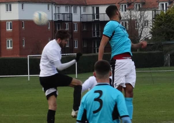 Bexhill United midfielder Nathan Lopez goes up for a header against AFC Varndeanians. Picture courtesy Mark Killy