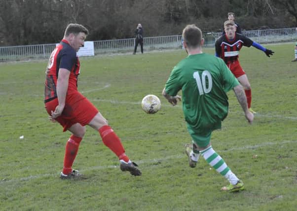 Hollington United defender Sean Ray tries to block a Rustington cross. Pictures by Simon Newstead
