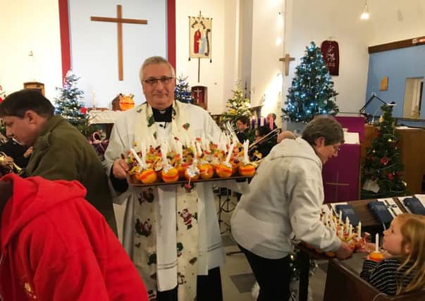 Father Steve Davies  with the Christingles at St Annes Church, East Wittering