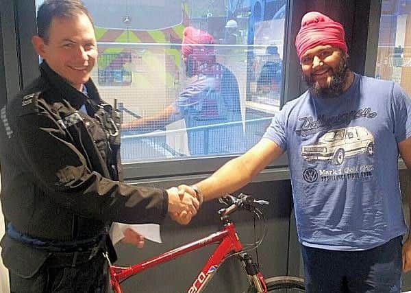 Reuniting an owner with his bike (Photograph: Sussex Police)
